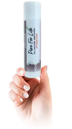 Прекрасна нежност на устните и хидратация! женска ръка държи шоколадовата конопена версия на Pure For Life балсам за устни